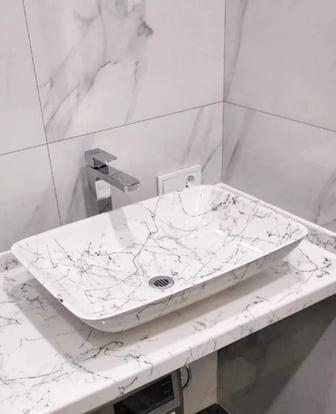 Каменная столешница с прямоугольной раковиной для ванной комнаты.
